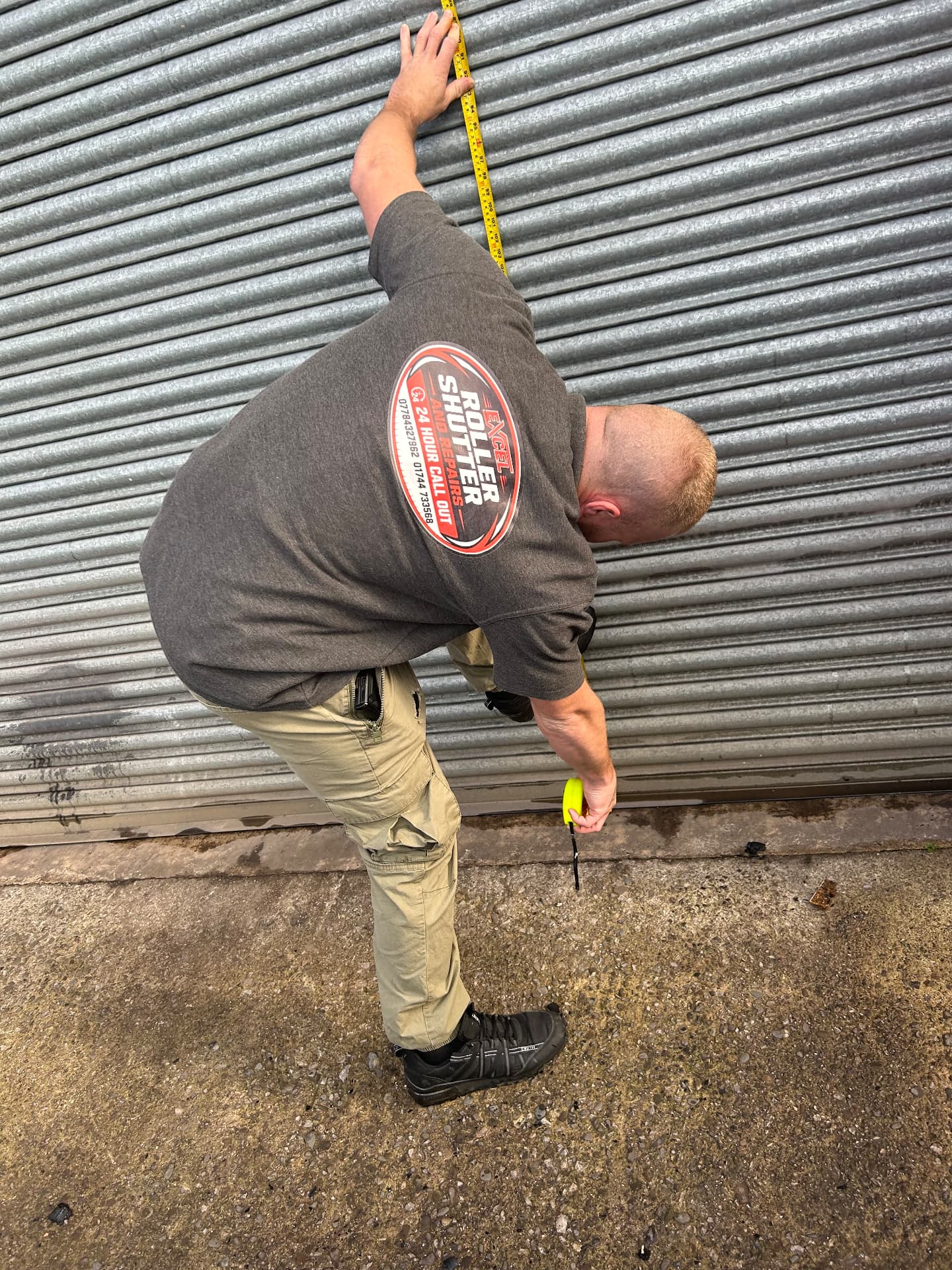 Excel engineer measuring a roller shutter on site